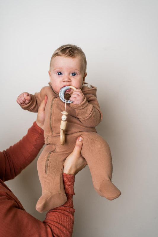 Baby holding natural wooden rattle with smooth edges